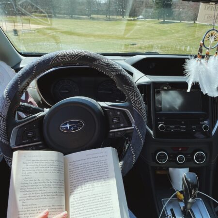 a POV photo of a person reading in the car