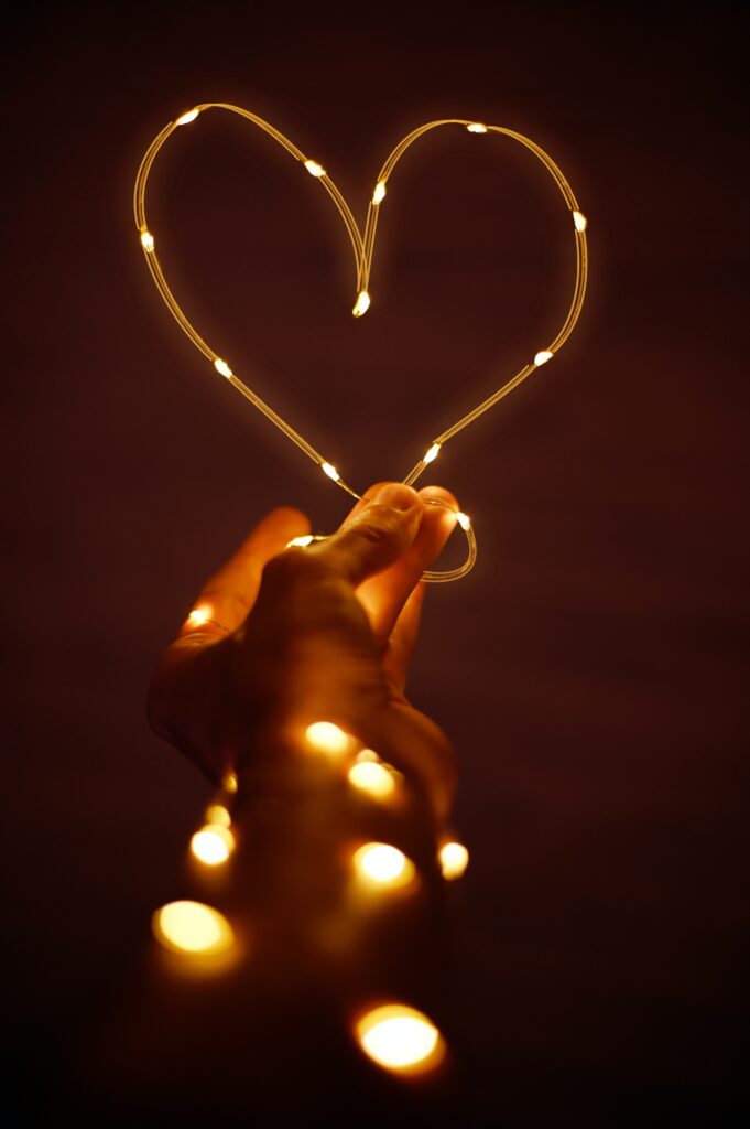 Hand holding heart made of fairy lights