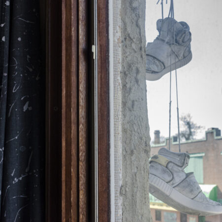 Shoes hanging outside window and curtain